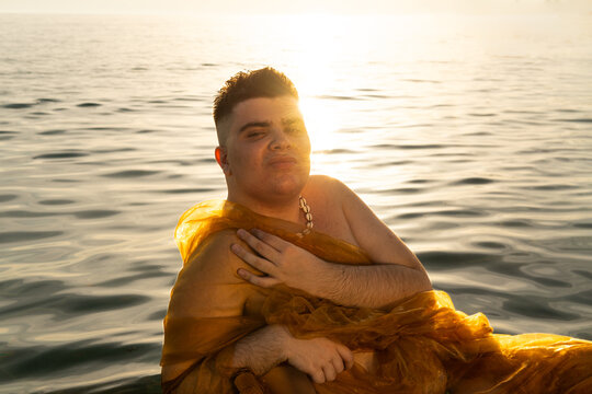 Non binary person creative portrait at sunset in the sea