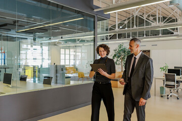 Formal businesspeople walking and talking in modern office