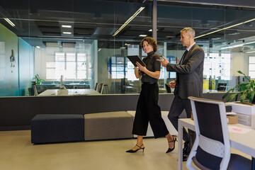 Busy formal businesspeople walking and talking in modern office