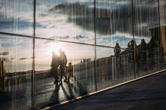 Reflections of People on Glass at Sunset