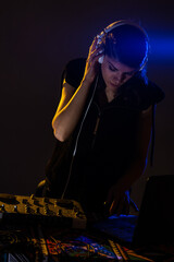 Female DJ playing music on a mixer. Blue light flare visible