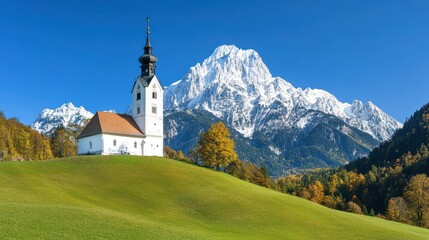 Fototapeta premium Scenic Alpine Church Surrounded by Majestic Snow-Capped Mountains