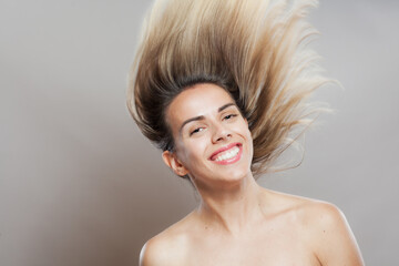 Beautiful girl fashion portrait with windy hair. Looking at camera.