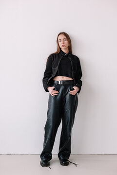 Young woman poses confidently in stylish black outfit