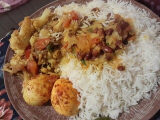 Fried eggs with rice, cauliflower, and lentil curry. Traditional Bangladeshi delicious and healthy food.