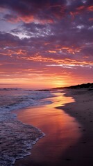 Dramatic sunset over a beach, reflecting in the water. Possible use Stock photo for nature, travel, or tourism
