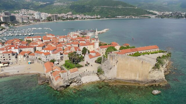 Aerial droen view Budva old town Stari harbour yachts Medieval Dubrovnik blue waters riviera mountains vacation holiday coastal Adriatic Mediterranean 