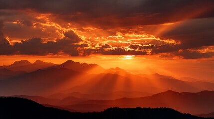 Dramatic sunset over mountain range; golden rays illuminating peaks; peaceful and inspiring landscape; ideal for desktop backgrounds or nature-themed posters
