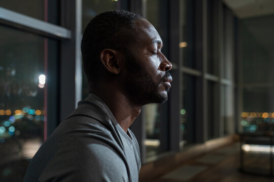 Man Meditating with Eyes Closed in a Modern Apartment