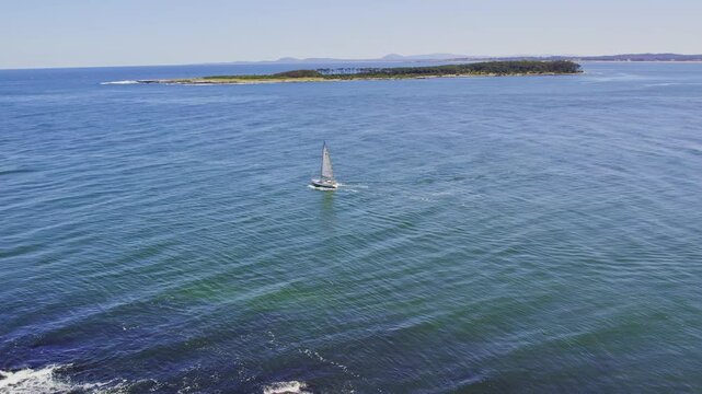 A small boat slowly sailing along the serene Uruguayan coastline near Punta del Este