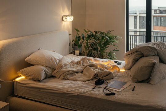 Cozy bedroom setting with disheveled bed and natural light