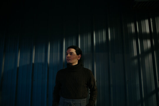 Person Standing Against Wall at Sunset with Shadows