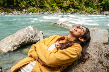  joyful woman relaxes by a  river having a Serene Moment in Nature