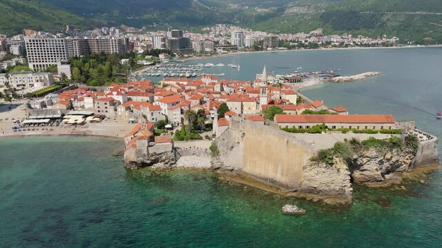 Aerial droen view Budva old town Stari harbour yachts Medieval Dubrovnik blue waters riviera mountains vacation holiday coastal Adriatic Mediterranean 