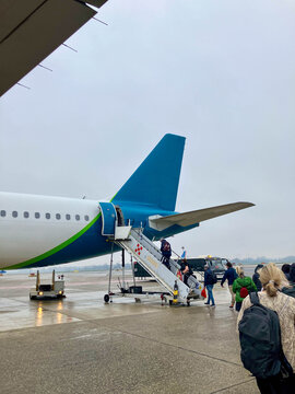 People boarding a plane in rainy day
