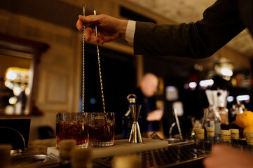 Bartender preparing cocktails in a cozy bar setting
