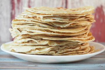Stack of freshly made flatbreads on a plate in a cozy kitchen