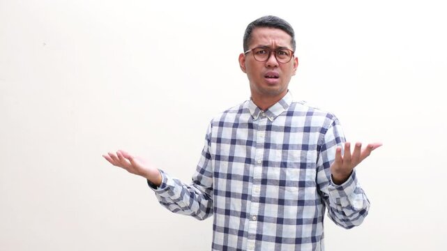 Adult Asian man showing confused and disbelief expression