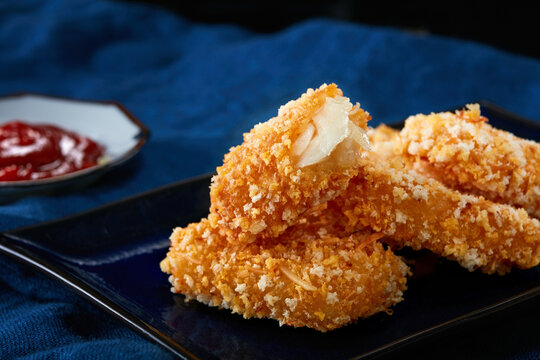 Closeup of fresh fried fish fillet on dark table