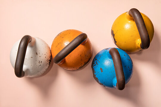 Colourful kettle bell weights on pink background