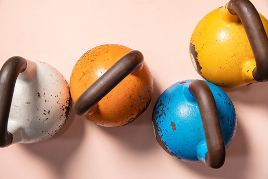 Colourful kettle bell weights on pink background