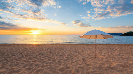 Serene beach scene featuring white umbrella golden sand, with stunning sunset reflecting calm