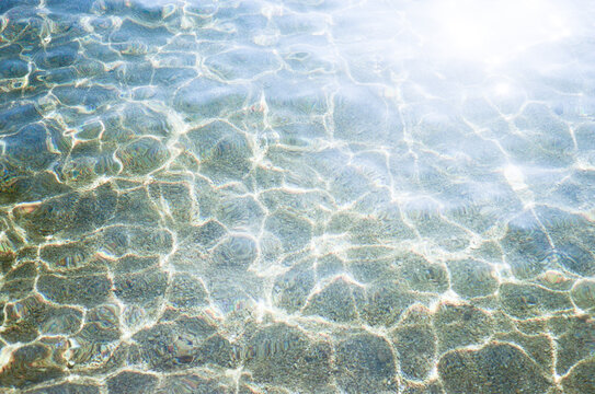 Abstract sun reflections on the water near the shore