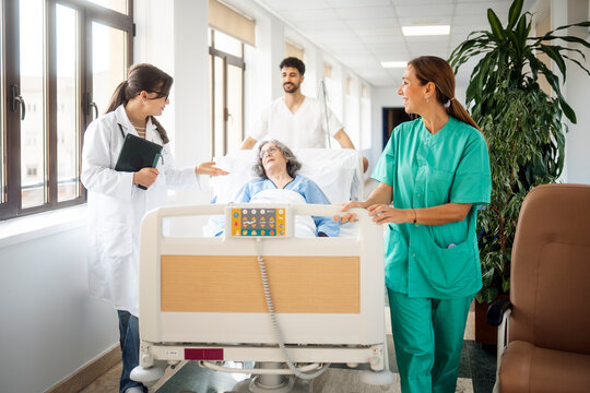 Medical team transporting senior patient on hospital bed