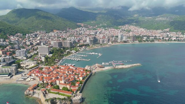 Aerial droen view Budva old town Stari harbour yachts Medieval Dubrovnik blue waters riviera mountains vacation holiday coastal Adriatic Mediterranean 
