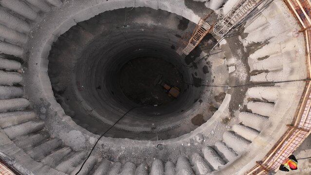 Deep Construction Site Shaft with Stairway and Industrial Equipment