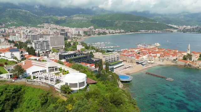 Aerial droen view Budva old town Stari harbour yachts Medieval Dubrovnik blue waters riviera mountains vacation holiday coastal Adriatic Mediterranean 