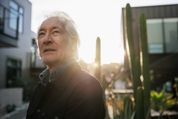 Portrait of an Elderly Man Outdoors in a Sunlit Urban Landscape