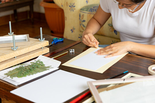 Woman artist using pencil and eraser to mark paper