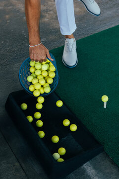 Golf balls and equipment setup on driving range mat