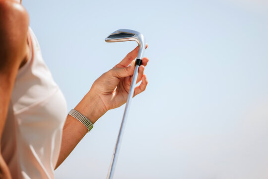Elegant woman's hand holding a golf club