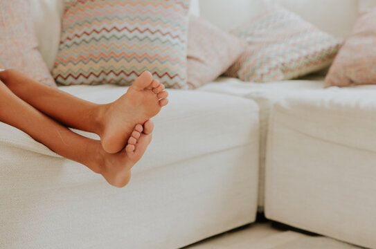 Relaxed toes on cozy sofa with patterned cushions