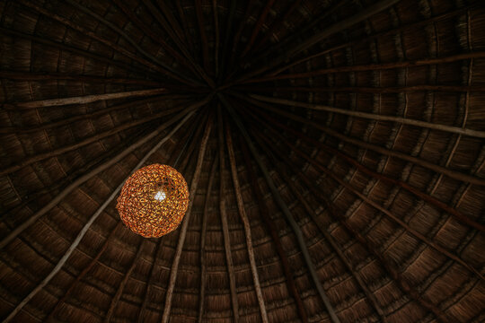 Rustic thatched ceiling with woven pendant light detail