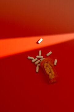 Spilled pill on red background