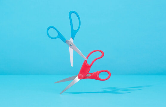 Still Life Entertwined Scissors on Blue Background 