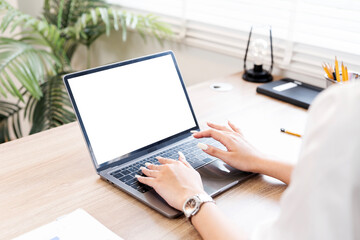 Cropped shot of woman hand working on laptop computer and peper work while sitting at the table..