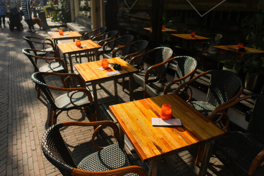 Sunlit tables on terrace of city cafe in Amsterdam