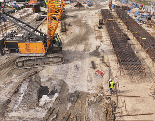 Excavator and Worker Build the Reinforcement Frame