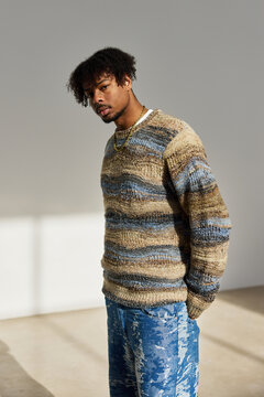 Stylish man poses in trendy outfit with blue and brown tones