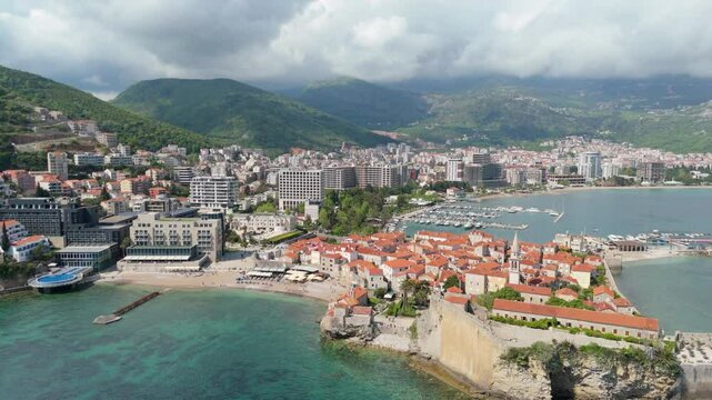Aerial droen view Budva old town Stari harbour yachts Medieval Dubrovnik blue waters riviera mountains vacation holiday coastal Adriatic Mediterranean 