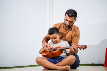 Middle Eastern Male Teaching Son Guitar Or Ukulele