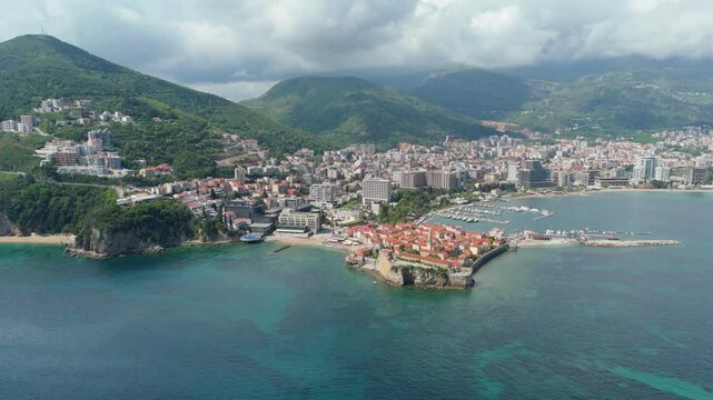 Aerial droen view Budva old town Stari harbour yachts Medieval Dubrovnik blue waters riviera mountains vacation holiday coastal Adriatic Mediterranean 