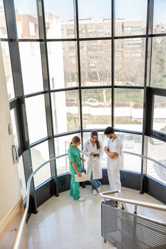 Medical team discussing patient data on digital tablet in hospital