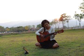 A confident young musician performs live on stage with a guitar and microphone, expressing passion...