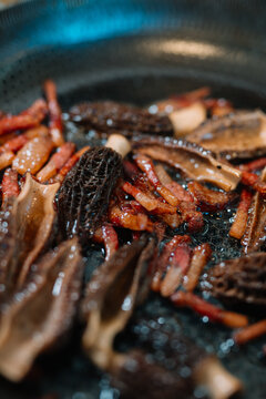 Fried morel mushrooms and bacon in a pan