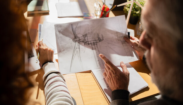 Engineers reviewing architectural plans under sunlight